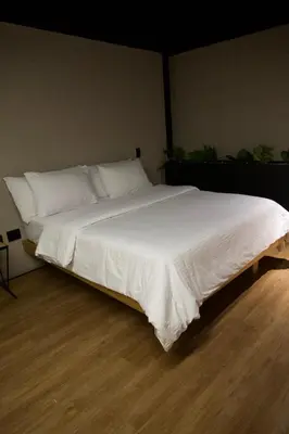 a large bed with white sheets and pillows at Hotel Casa Leon Rooftop in Rionegro
