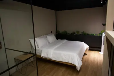 a bedroom with a bed with white sheets and pillows at Hotel Casa Leon Rooftop in Rionegro