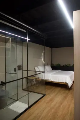 a bedroom with a bed and a glass wall at Hotel Casa Leon Rooftop in Rionegro