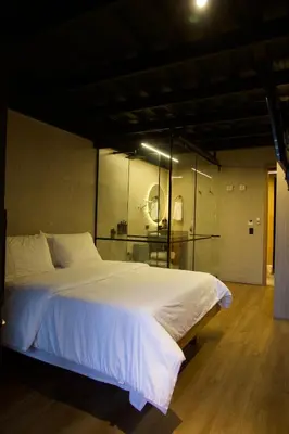 a bedroom with a large white bed with a glass wall at Hotel Casa Leon Rooftop in Rionegro