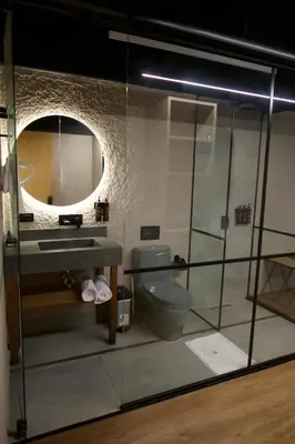 a bathroom with a sink and a mirror and a toilet at Hotel Casa Leon Rooftop in Rionegro