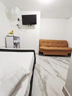a living room with a couch and a television at Casa Eclat in Medellín