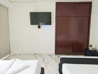 a room with a tv and a bed and a door at Casa Eclat in Medellín