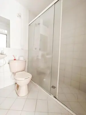 a white bathroom with a toilet and a shower at Casa Eclat in Medellín
