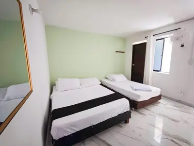 a room with two beds and a mirror at Casa Eclat in Medellín