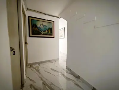 a hallway with marble floors and a painting on the wall at Casa Eclat in Medellín