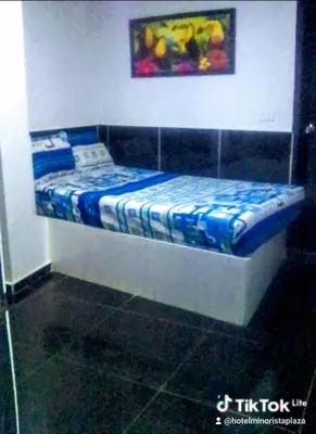 a small bed in a room with a painting on the wall at Hotel Minorista plaza in Medellín