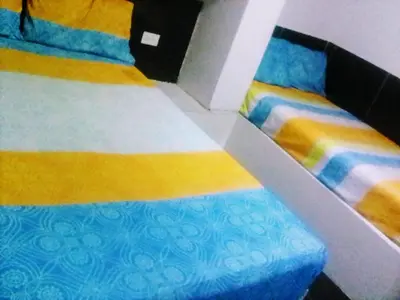 a bedroom with two beds with colorful sheets at Hotel Minorista plaza in Medellín