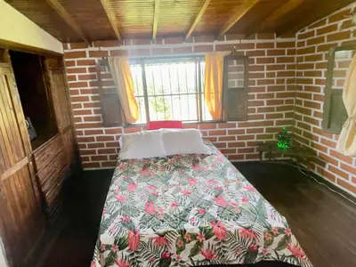 a small room with a bed in a brick wall at Casa Campestre Familiar in Medellín