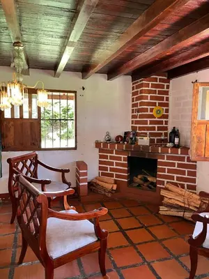 a living room with a brick fireplace and chairs at Casa Campestre Familiar in Medellín