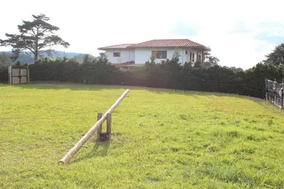 a wooden fence in a field in front of a house at Casa Campestre Familiar in Medellín