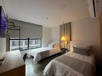 a bedroom with two beds and a window at Akela30 Hotel in Medellín
