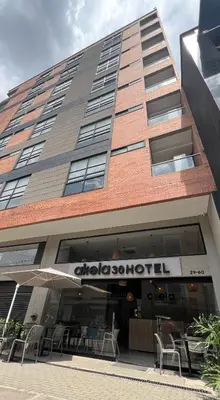a building with tables and chairs in front of it at Akela30 Hotel in Medellín