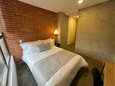 a bedroom with a bed against a brick wall at Akela30 Hotel in Medellín