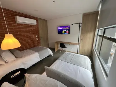a hotel room with two beds and a tv at Akela30 Hotel in Medellín