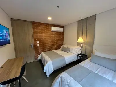 a hotel room with two beds and a table at Akela30 Hotel in Medellín