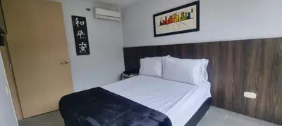 a small bedroom with a bed with a wooden headboard at Laureles City Retreat, Cold AC in Medellín
