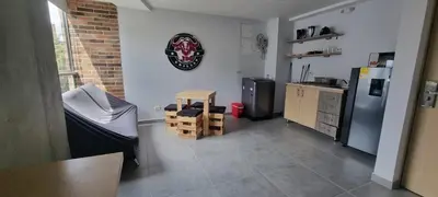 a room with a kitchen with a refrigerator and a table at Laureles City Retreat, Cold AC in Medellín