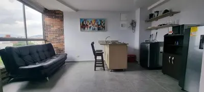 a living room with a black couch and a kitchen at La 70, Laureles Condo, Cold AC in Medellín