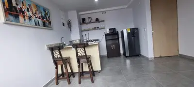 a kitchen with two bar stools and a refrigerator at La 70, Laureles Condo, Cold AC in Medellín