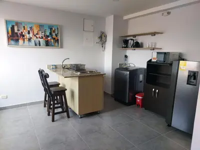 a kitchen with a counter and a sink and a refrigerator at La 70, Laureles Condo, Cold AC in Medellín