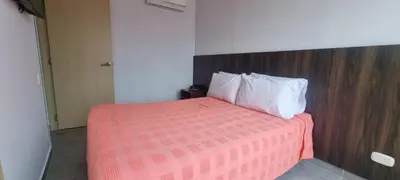 a bedroom with a bed with a red blanket and white pillows at Best Laureles location and price in Medellín