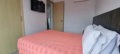 a bedroom with a bed with a orange comforter and pillows at Best Laureles location and price in Medellín