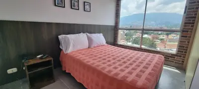 a bedroom with a bed and a large window at Great Laureles views, Cold AC and best price in Medellín