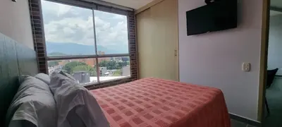 a bedroom with a bed and a large window at Great Laureles views, Cold AC and best price in Medellín