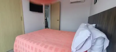 a bedroom with a bed with a pink blanket and pillows at Great Laureles views, Cold AC and best price in Medellín