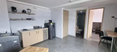 a kitchen with a refrigerator and a table in it at Great Laureles views, Cold AC and best price in Medellín