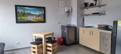 a kitchen with a counter and a stool in a room at Great Laureles views, Cold AC and best price in Medellín