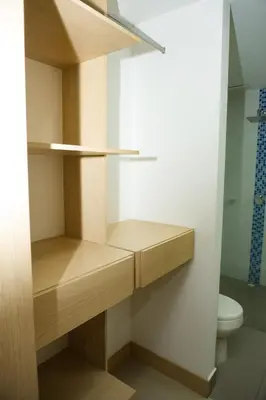 a small bathroom with wooden shelves and a toilet at Luxurious apartment in Las Palmas in Medellín