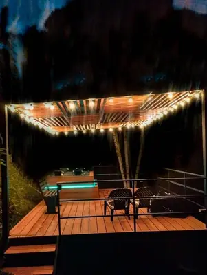 a deck with two chairs and lights on it at Cabaña con Jacuzzi cerca al Peñol in Chiquinquirá
