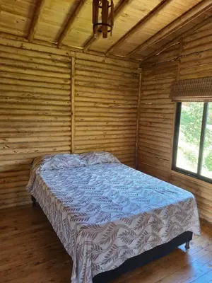 a bedroom with a bed in a wooden room at Cabaña con Jacuzzi cerca al Peñol in Chiquinquirá