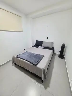 a bedroom with a bed in a white room at Elegant apartment Laureles Estadio in Medellín
