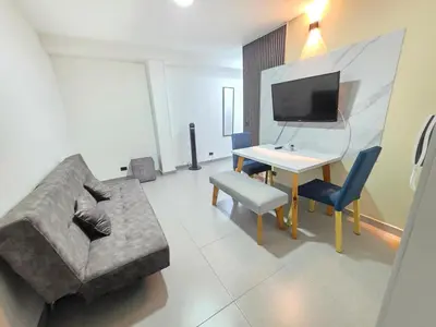 a living room with a couch and a table and a tv at Elegant apartment Laureles Estadio in Medellín