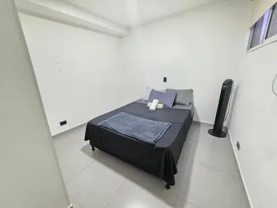 a bedroom with a bed in a white room at Elegant apartment Laureles Estadio in Medellín