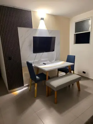 a desk with two chairs and a computer monitor at Elegant apartment Laureles Estadio in Medellín