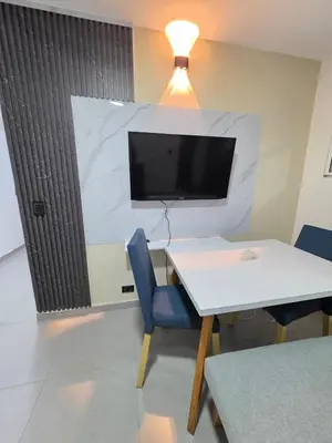 a room with a table and a tv on a wall at Elegant apartment Laureles Estadio in Medellín