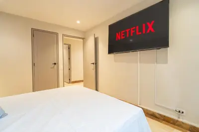 a bedroom with a bed and a television on the wall at Lux Lleras l Daily Cleaning l AC l Visitrs Allowed in Medellín