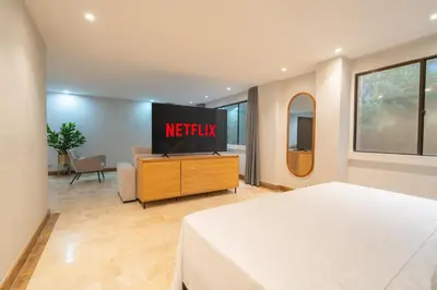 a hotel room with a bed and a television at Lux Lleras l Daily Cleaning l AC l Visitrs Allowed in Medellín