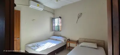 a small room with two beds and a window at Casa de descanso en Doradal Hacienda Napoles in Doradal