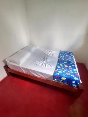 a bed sitting in a room with a red floor at Casa de descansó la pradera