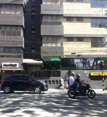two people riding a motorcycle on a city street at Hotel Ruiseñor Itagui in Itagüí
