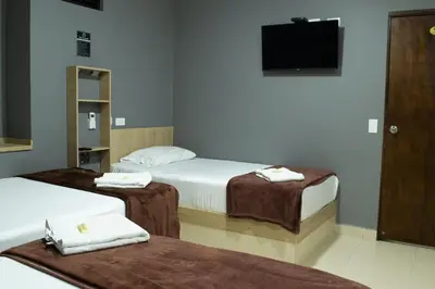 a hotel room with two beds and a television at Hotel Ruiseñor Itagui in Itagüí