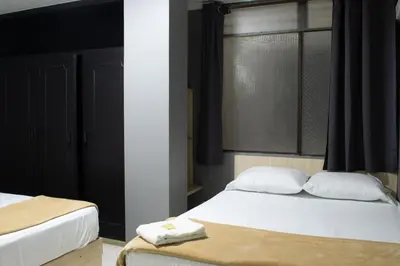 a bedroom with two beds and a window at Hotel Ruiseñor Itagui in Itagüí