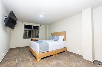 a bedroom with a bed and a flat screen tv at Hotel Bossanova in Rionegro
