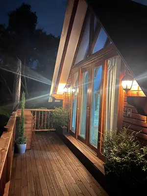 a large wooden deck with sliding glass doors on a house at Qimera Ecolodge - Cabaña a 7 Min del Aeropuerto JMC in Guarne