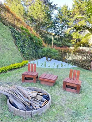 two chairs and a fire pit in a yard at Qimera Ecolodge - Cabaña a 7 Min del Aeropuerto JMC in Guarne